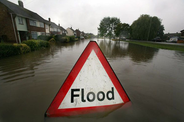 A flood warning sign submerged in flood water