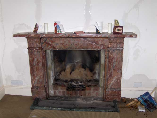 A residential fireplace that has suffered from fire damage.