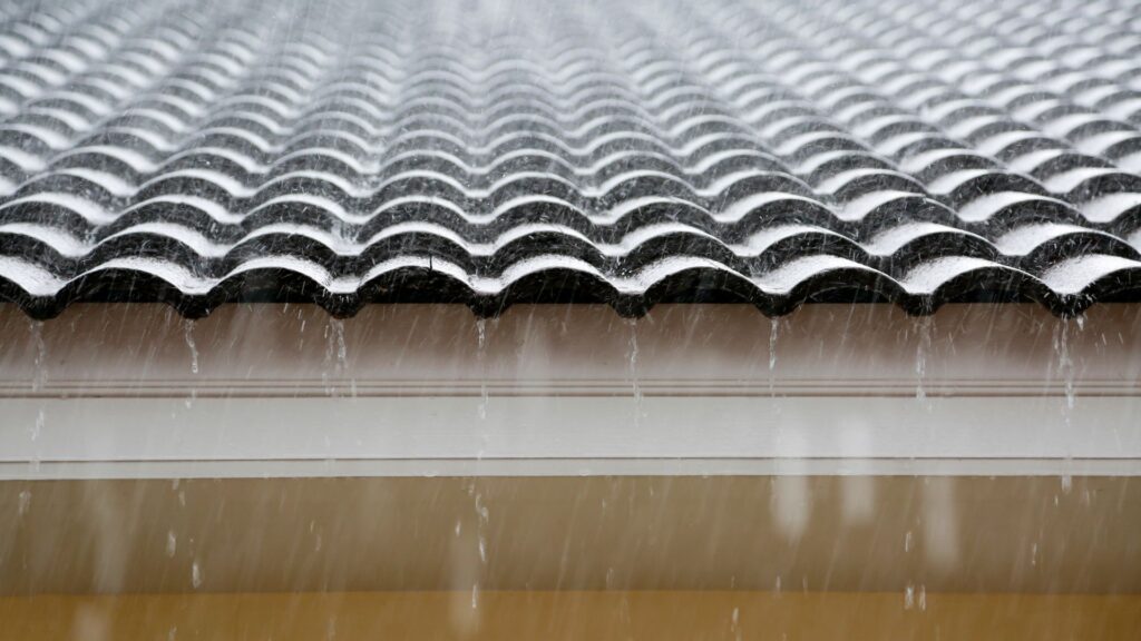 Close up of tiles roof in the rain to help illustrate Vinci's tips on how to stop roof leaks.