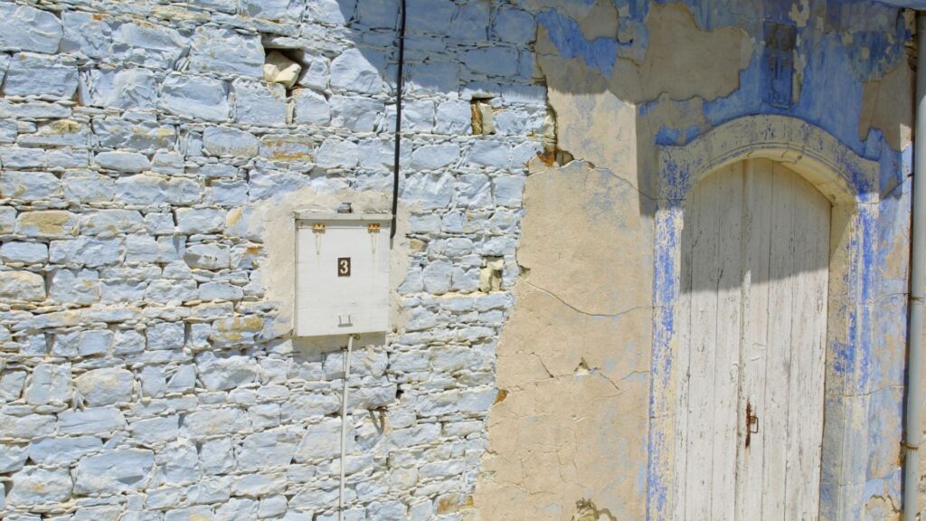 An old stone building with flecked paint to illustrate the delicate work required to remove paint from stone.