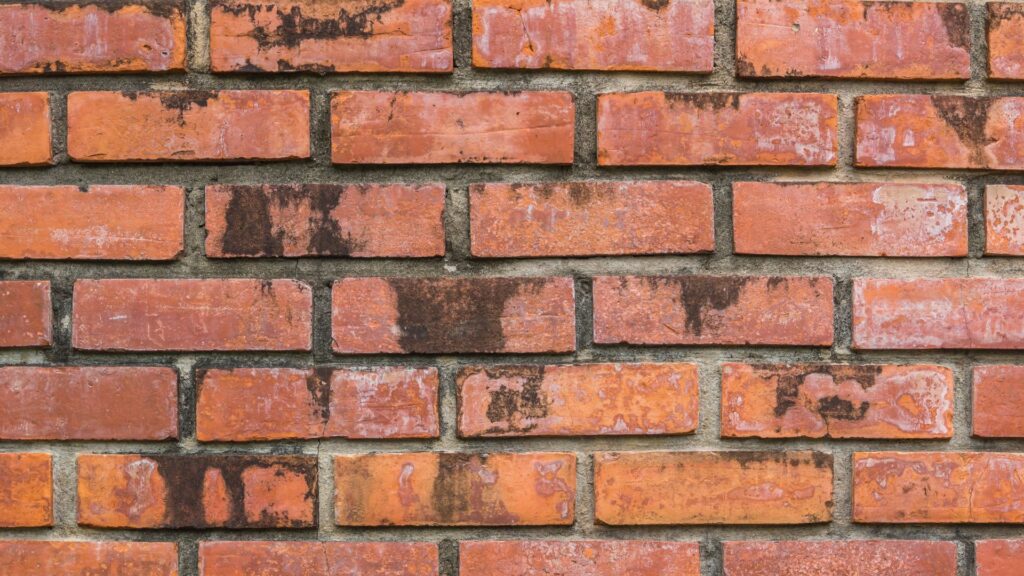 A dirty red brick wall to help illustrate the processes required to successfully clean brick walls.
