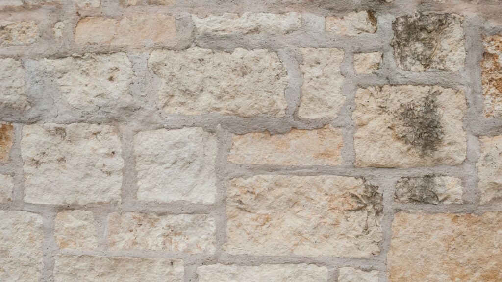 A stone wall with dirt on it to help illustrate how best to clean stone walls.