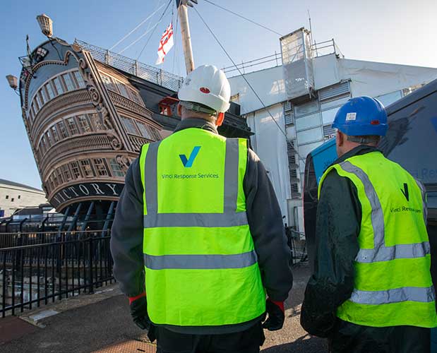 Vinci technicians working to clean the HMS Victory dry dock, at Portsmouth Historic Dockyard.