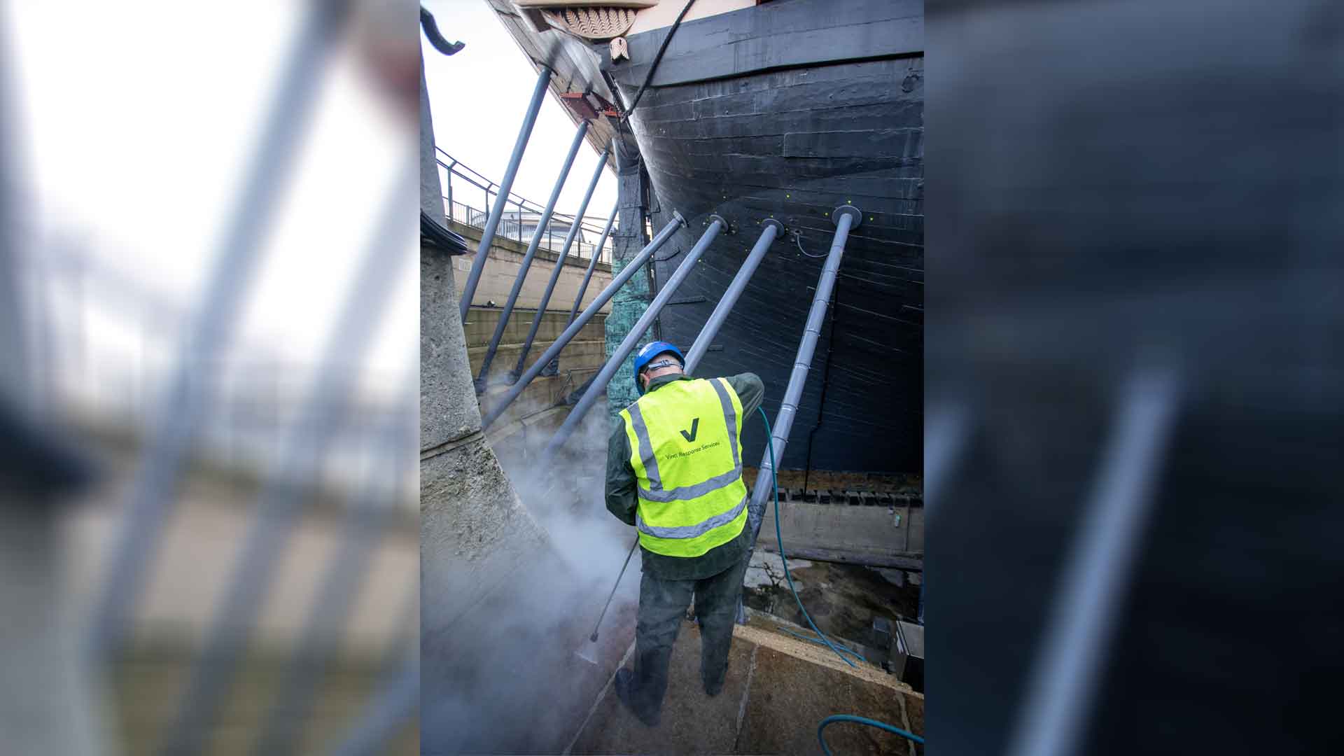 Vinci technicians working to clean the HMS Victory dry dock, at Portsmouth Historic Dockyard.